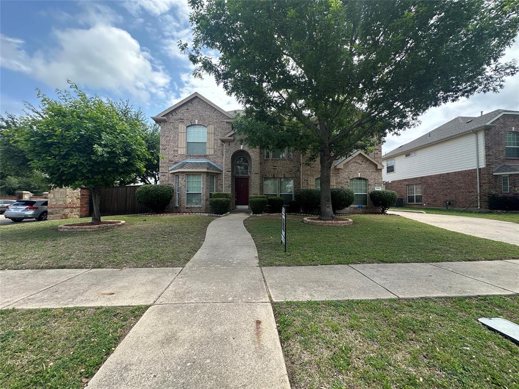 Traditional-style home with brick siding and a front yard