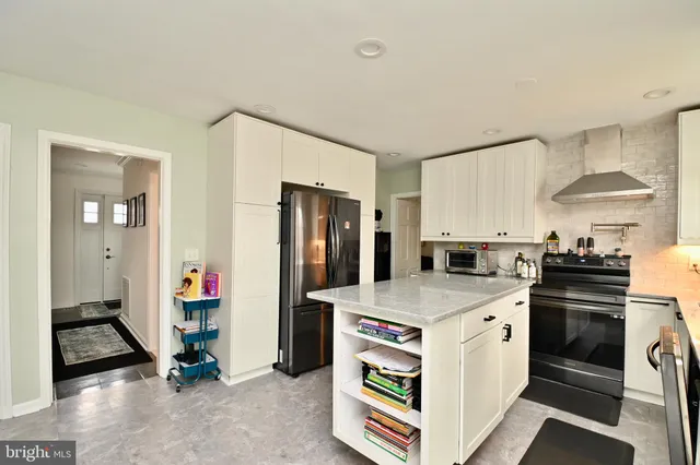 a kitchen with a refrigerator and a stove top oven