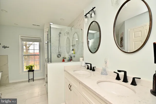a bathroom with a granite countertop double vanity sink and a mirror