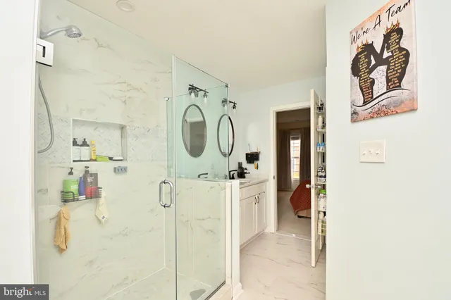 a en suite bathroom with a sink mirror and shower