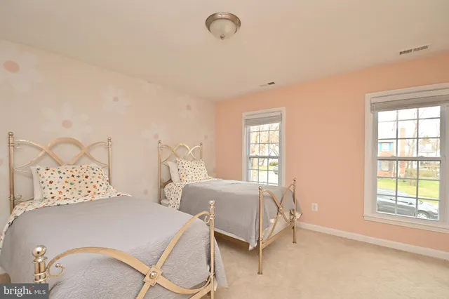 a bedroom with two beds and windows