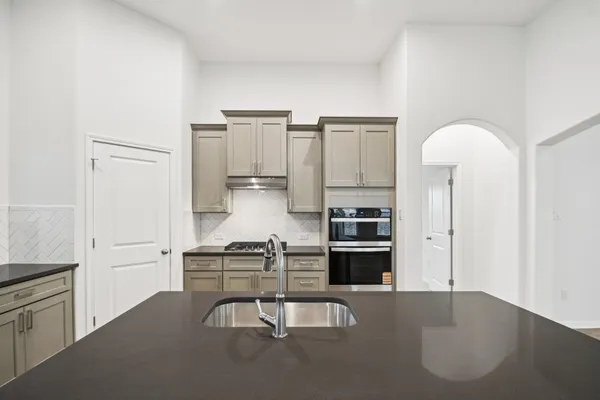 a kitchen with stainless steel appliances granite countertop a sink stove and refrigerator