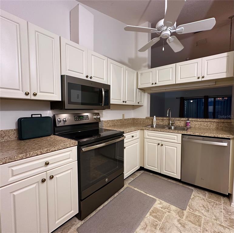 5685 Marina Drive, Unit 4 Sebastian, FL 32958 - Photo 12 of 19 a kitchen with granite countertop a sink stainless steel appliances and white cabinets