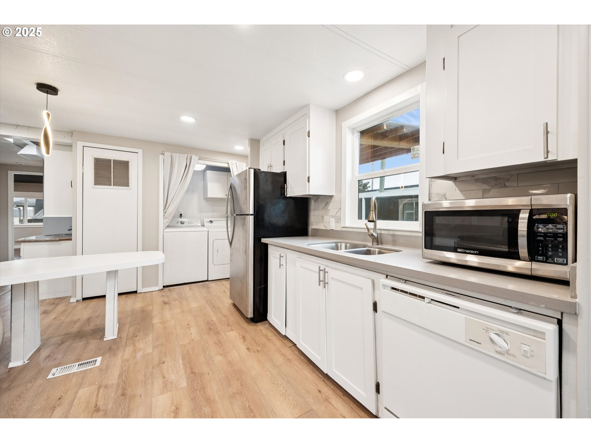 10701 Southeast Highway 212, Unit P6 Clackamas, OR 97015 - Photo 12 of 42 a kitchen with stainless steel appliances kitchen island granite countertop a refrigerator a stove top oven a sink dishwasher and white cabinets with wooden floor