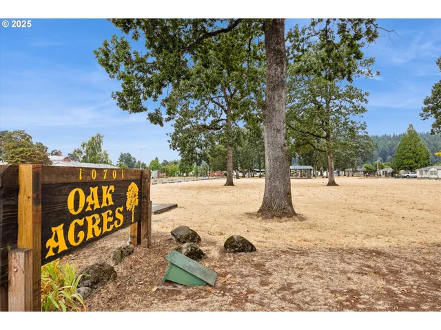 a view of a house with a big yard and large trees
