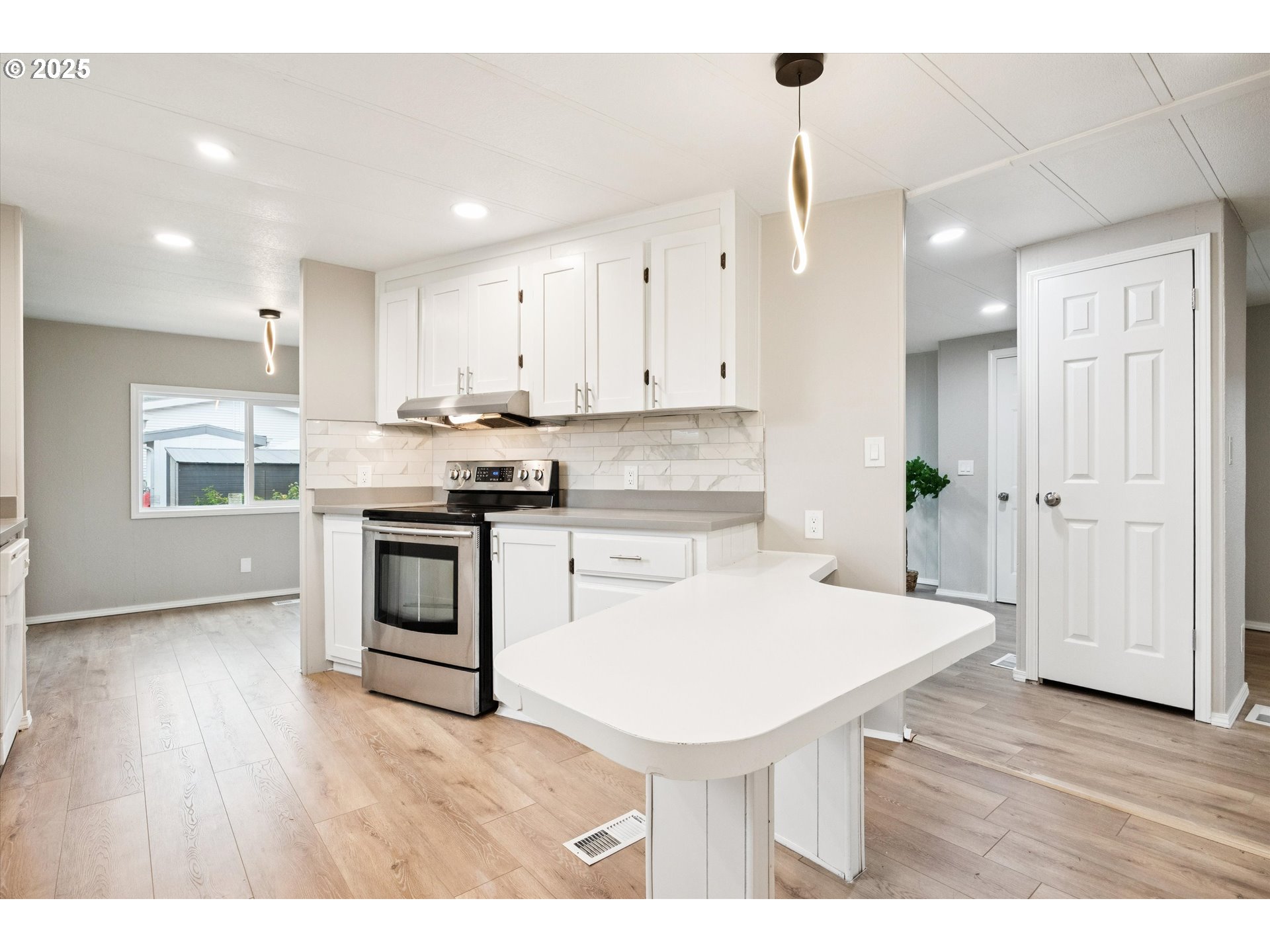 10701 Southeast Highway 212, Unit P6 Clackamas, OR 97015 - Photo 10 of 42 a kitchen with kitchen island a white counter top space cabinets and stainless steel appliances