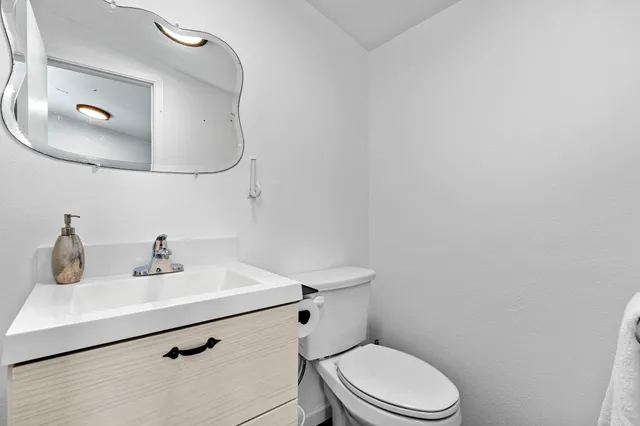 a bathroom with a sink mirror and toilet