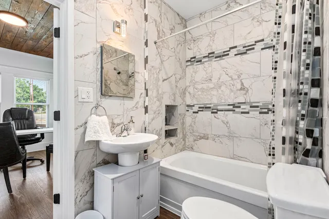 a bathroom with a sink toilet a mirror and shower