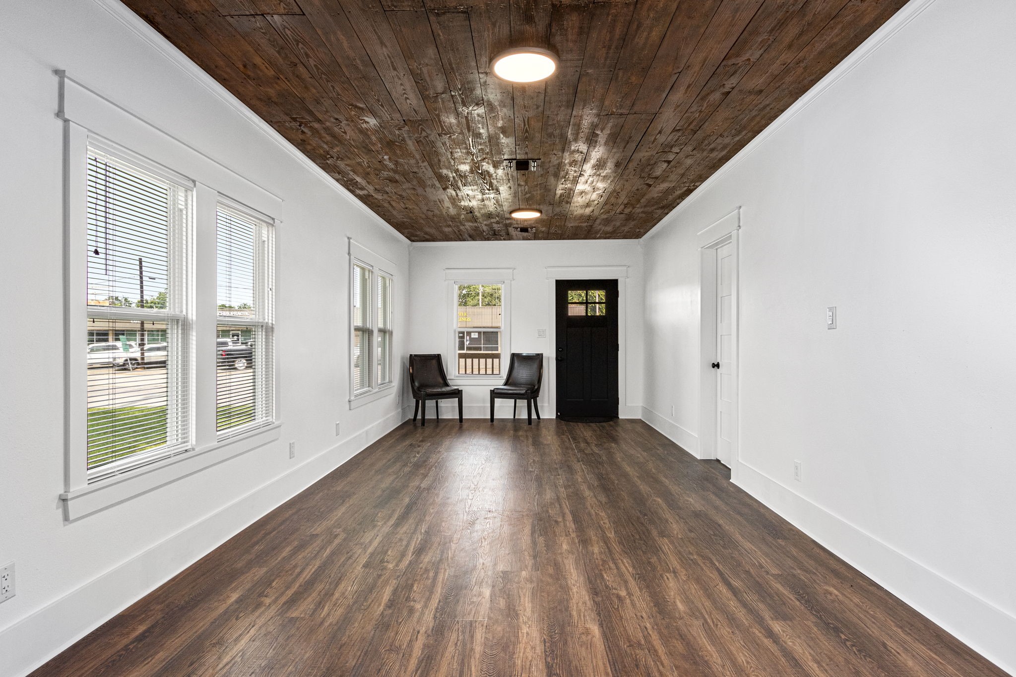 1138 Fannin Street Columbus, TX 78934 - Photo 6 of 25 a view of an empty room with wooden floor and a window