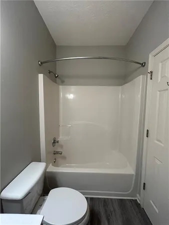 a bathroom with a toilet and a bath tub
