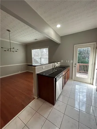 a kitchen with granite countertop a stove a sink and white cabinets