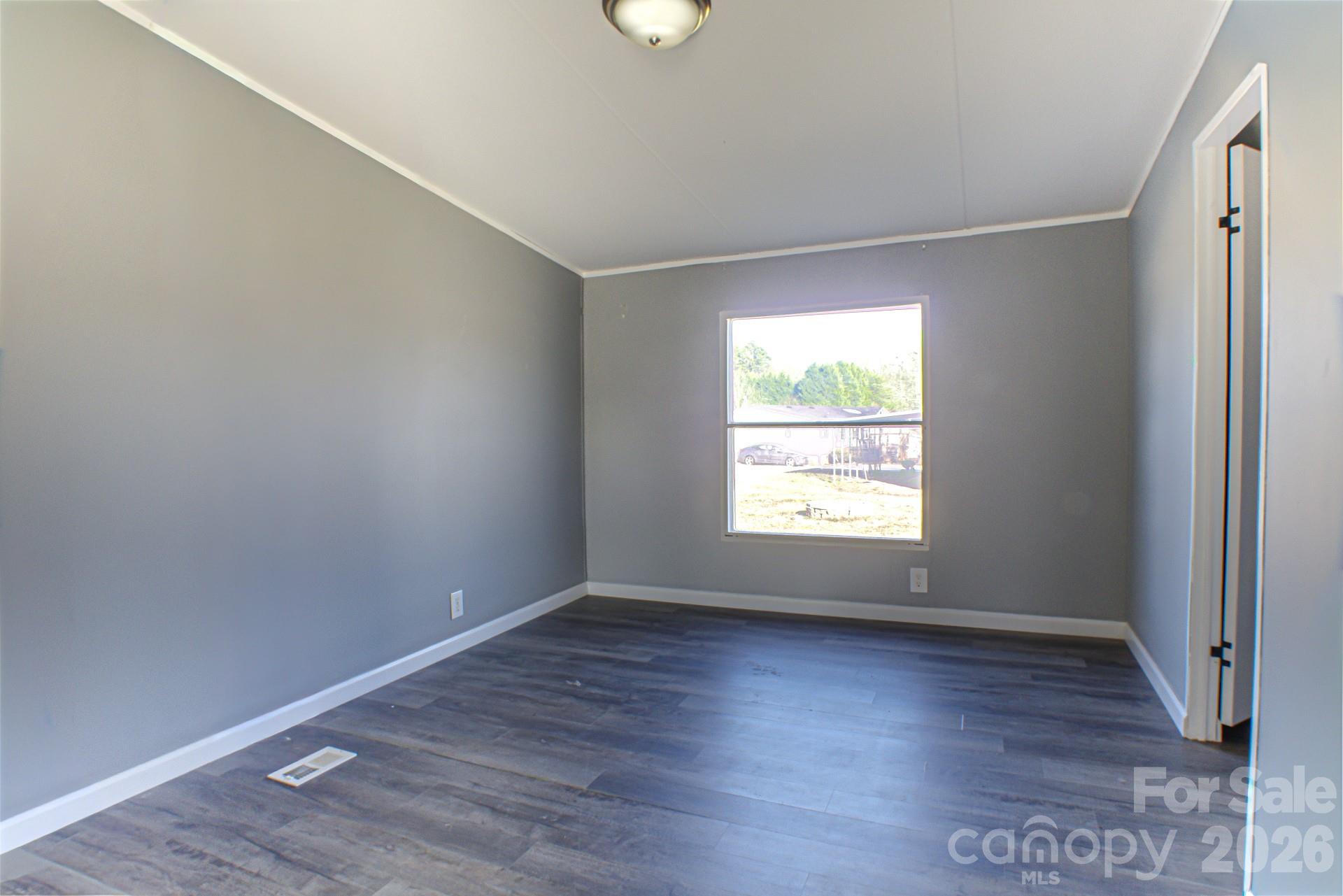 4610 Deal Road Claremont, NC 28610 - Photo 9 of 13 an empty room with wooden floor and windows