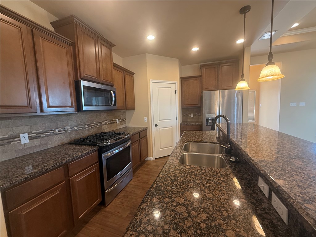 14510 Dragonet Street Corpus Christi, TX 78418 - Photo 5 of 19 a kitchen with stainless steel appliances granite countertop a sink a stove and a refrigerator
