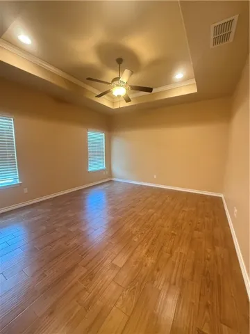 a view of an empty room with wooden floor