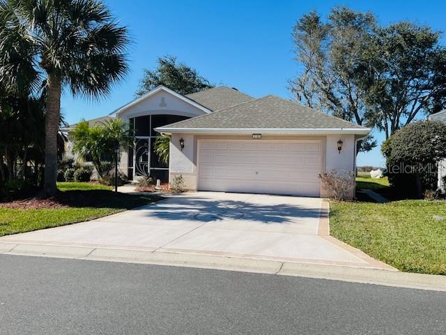 front view of house with a yard and palm trees