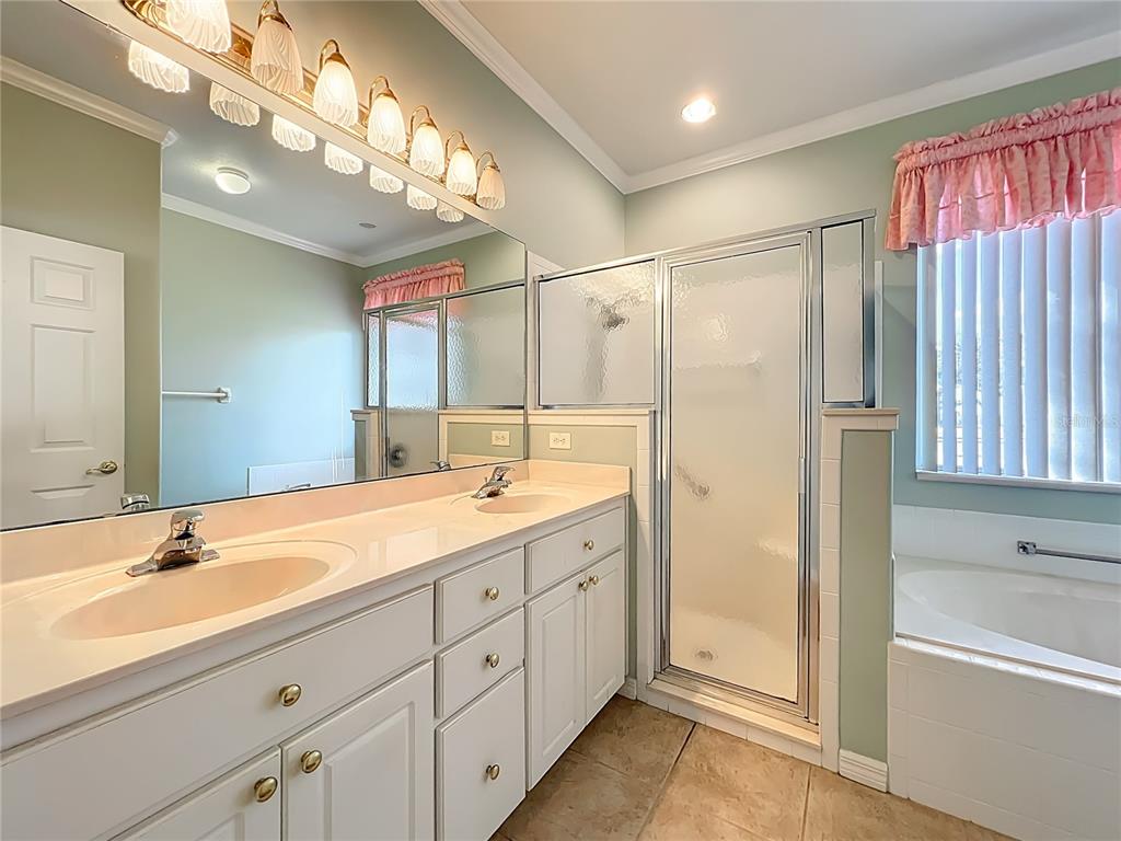 5685 Gulf Stream Street Tavares, FL 32778 - Photo 39 of 78 a spacious bathroom with a double vanity sink a large mirror a shower and a bathtub
