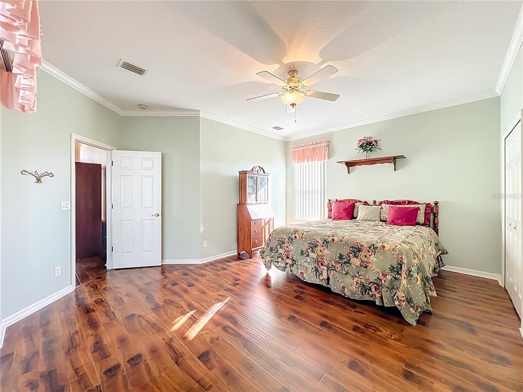 5685 Gulf Stream Street Tavares, FL 32778 - Photo 41 of 78 a bedroom with a bed and a chandelier