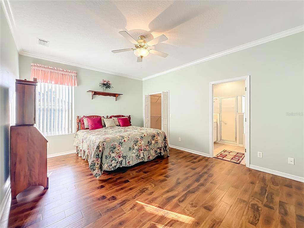 5685 Gulf Stream Street Tavares, FL 32778 - Photo 42 of 78 a bedroom with a large bed and a chandelier