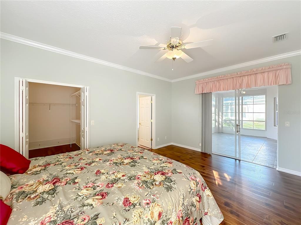 5685 Gulf Stream Street Tavares, FL 32778 - Photo 44 of 78 a bedroom with a bed and a chandelier