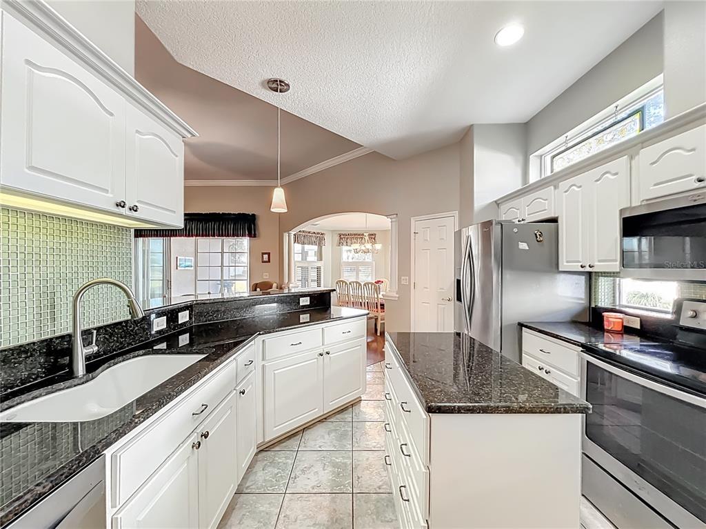 5685 Gulf Stream Street Tavares, FL 32778 - Photo 46 of 78 a kitchen with stainless steel appliances granite countertop a sink and cabinets