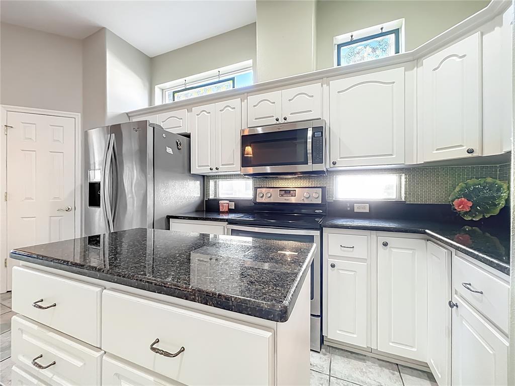 5685 Gulf Stream Street Tavares, FL 32778 - Photo 48 of 78 a kitchen with stainless steel appliances granite countertop a sink a stove and cabinets