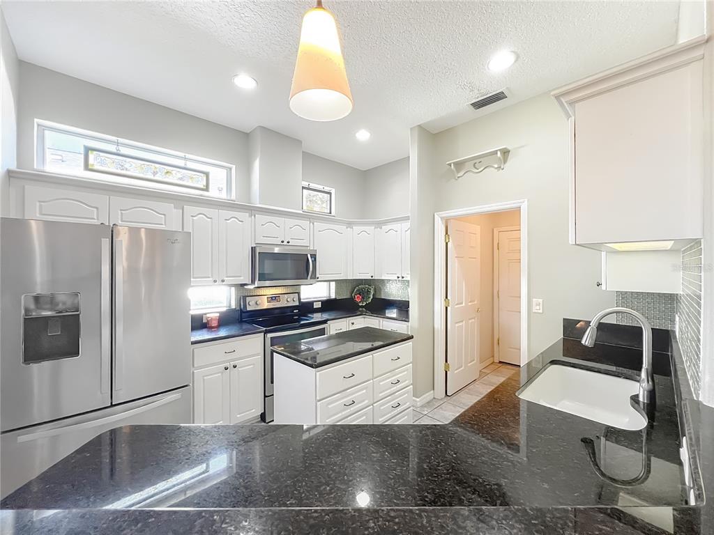 5685 Gulf Stream Street Tavares, FL 32778 - Photo 52 of 78 a kitchen with granite countertop a refrigerator stove and sink