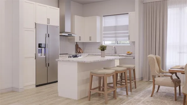 a kitchen with stainless steel appliances a table chairs and a refrigerator