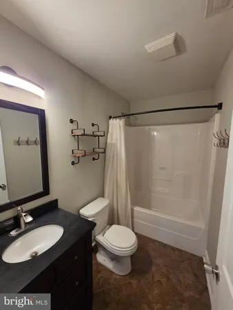 a bathroom with a granite countertop sink toilet a mirror and shower