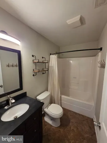 a bathroom with a granite countertop sink toilet a mirror and shower