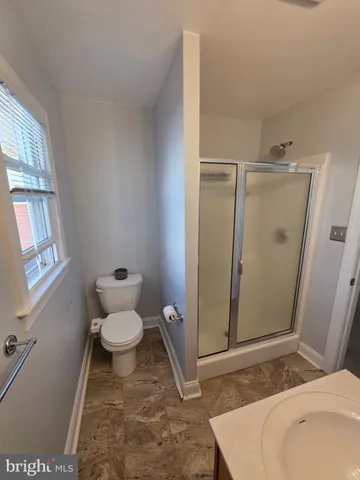 a bathroom with a toilet and a shower