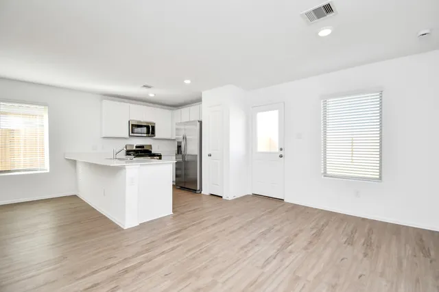 a view of kitchen with wooden floor and electronic appliances