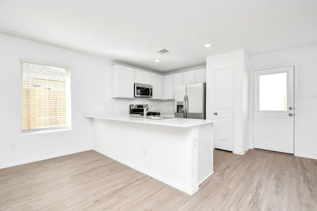 a view of kitchen with wooden floor and electronic appliances