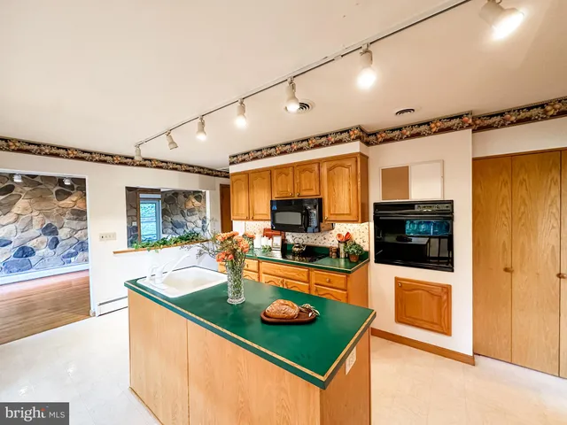 a kitchen with stainless steel appliances granite countertop a sink and a refrigerator