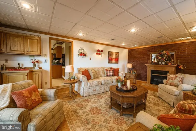 a living room with furniture a fireplace and a kitchen view