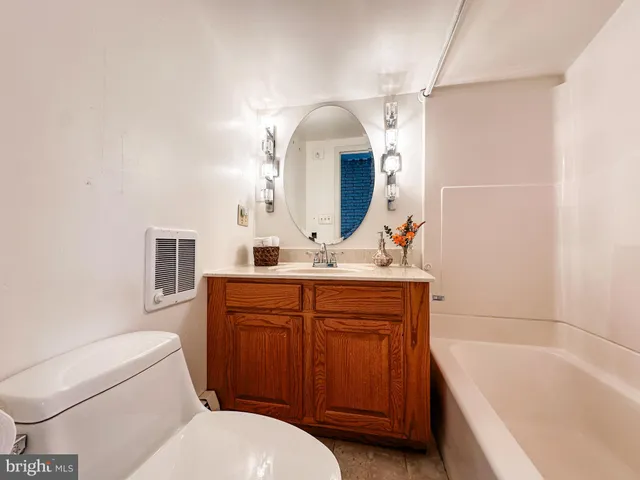 a bathroom with a sink toilet vanity and bathtub