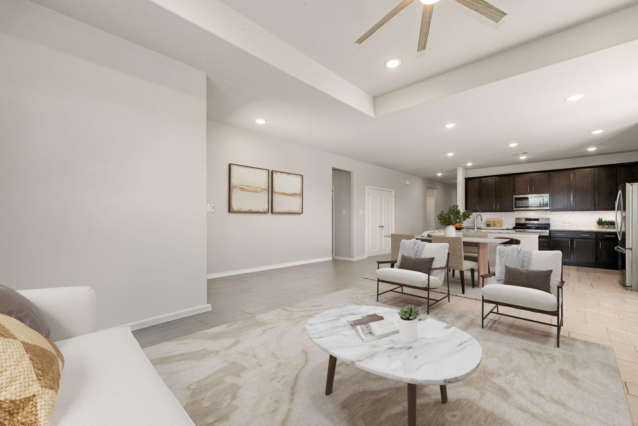 8414 Divot Trace Fulshear, TX 77441 - Photo 11 of 25 The space features recessed lighting, a contemporary ceiling fan, and crisp white walls that enhance the bright, airy atmosphere. Large windows invite an abundance of natural light, creating a sophisticated flow that leads directly into the chef-inspired kitchen.