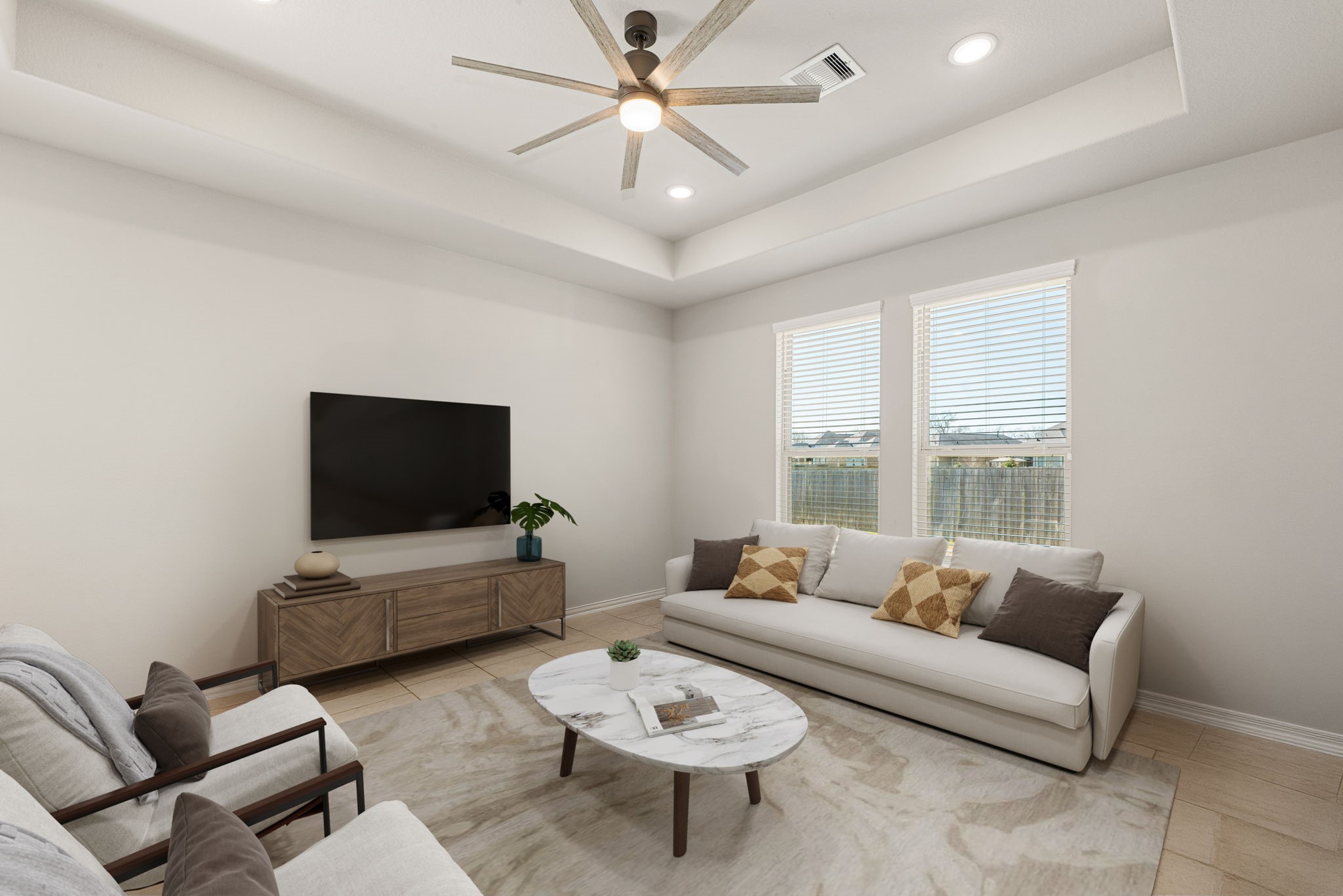 8414 Divot Trace Fulshear, TX 77441 - Photo 12 of 25 This spacious living area features an elegant tray ceiling with a modern ceiling fan and integrated recessed lighting. Large windows with custom blinds allow for plenty of natural light, while the neutral-toned flooring and crisp white walls provide a clean, contemporary canvas. The room's generous proportions and open layout make it an ideal space for both relaxation and entertainment.