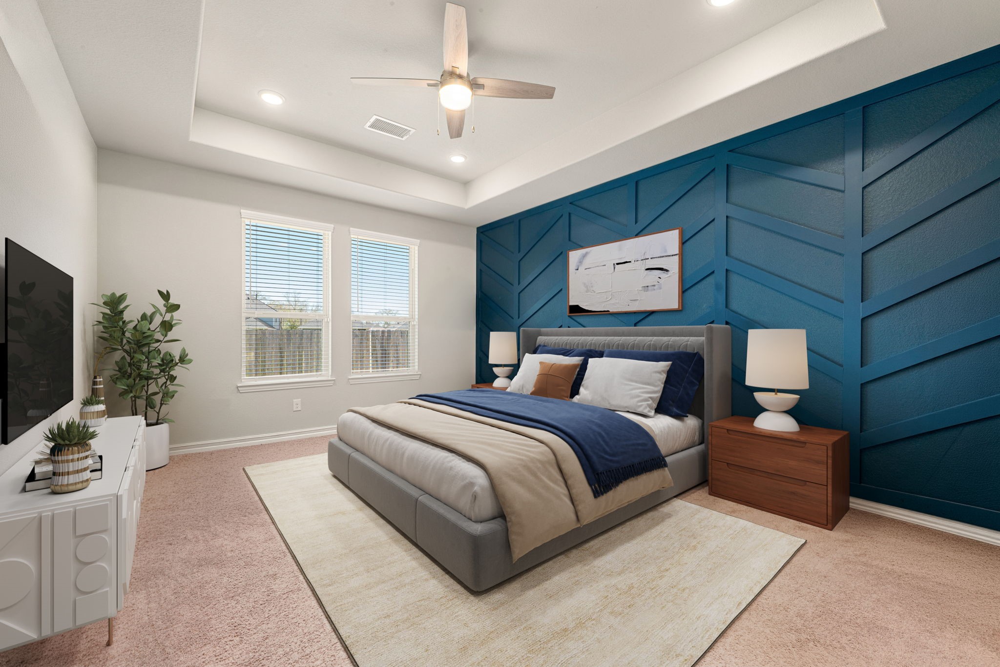 8414 Divot Trace Fulshear, TX 77441 - Photo 13 of 25 This sophisticated primary suite showcases a stunning deep blue accent wall with contemporary textured paneling. The spacious layout is enhanced by an elegant tray ceiling featuring a modern ceiling fan and integrated recessed lighting. Large windows invite an abundance of natural light, while the neutral-toned flooring and crisp white walls create a serene and airy retreat.