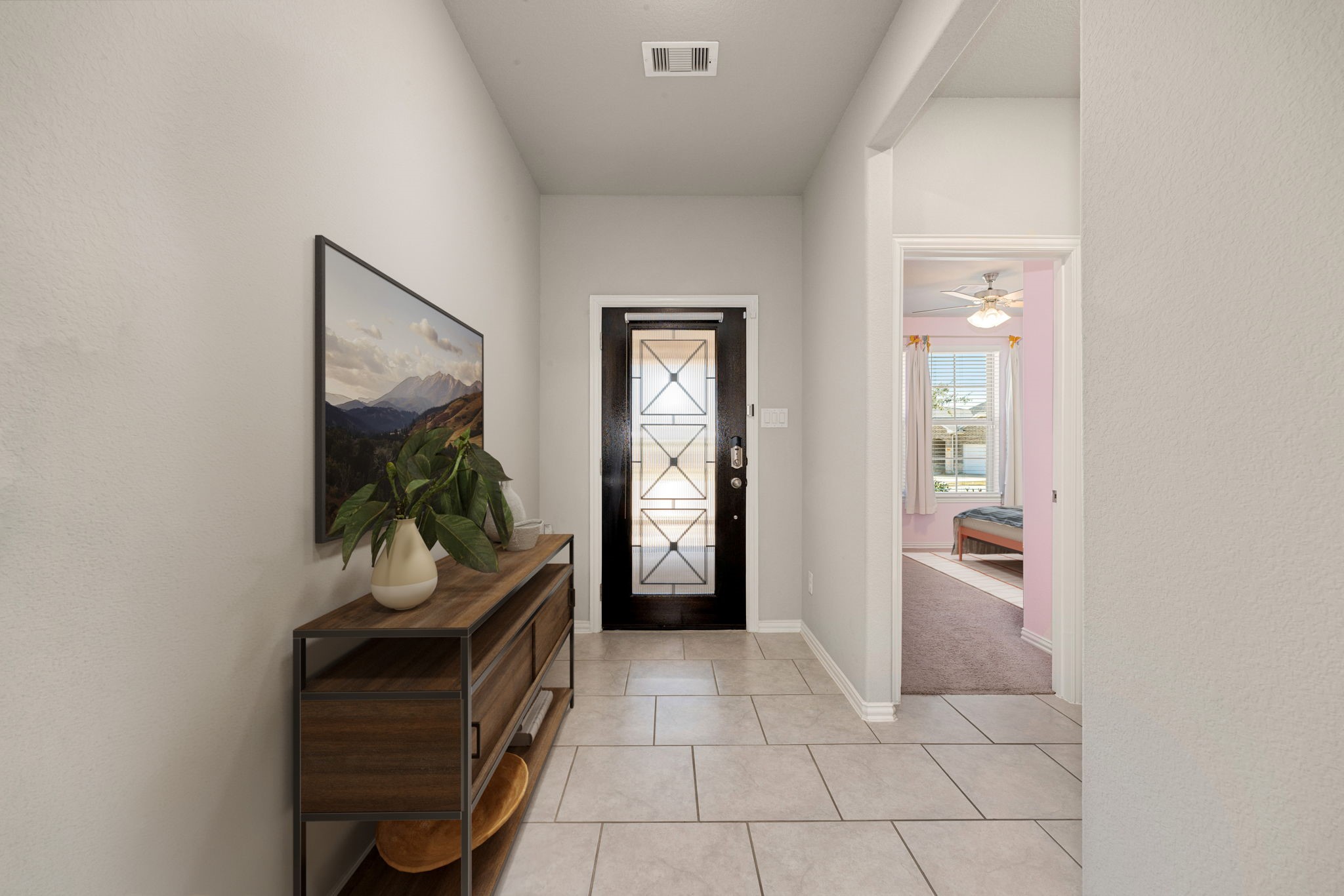 8414 Divot Trace Fulshear, TX 77441 - Photo 4 of 25 This light-filled entryway offers an inviting first impression, featuring neutral-toned flooring and a contemporary layout. The clean lines and modern front door with glass inserts create a seamless flow into the heart of the home.