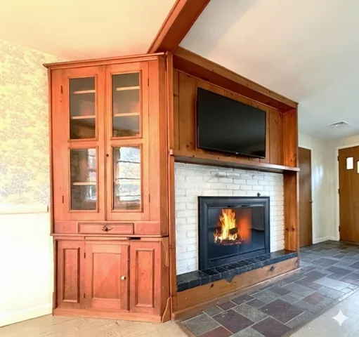 a living room with a fireplace a flat screen tv and a fireplace