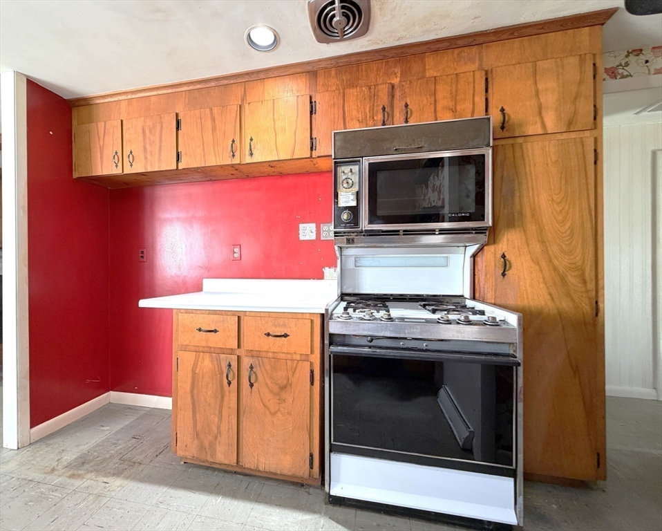 43 Chandler Avenue Walpole, MA 02081 - Photo 9 of 23 a kitchen with granite countertop a stove top oven microwave and cabinets
