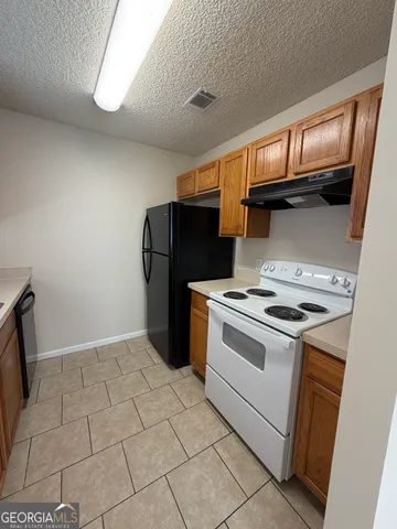 a kitchen with a sink a refrigerator and cabinets