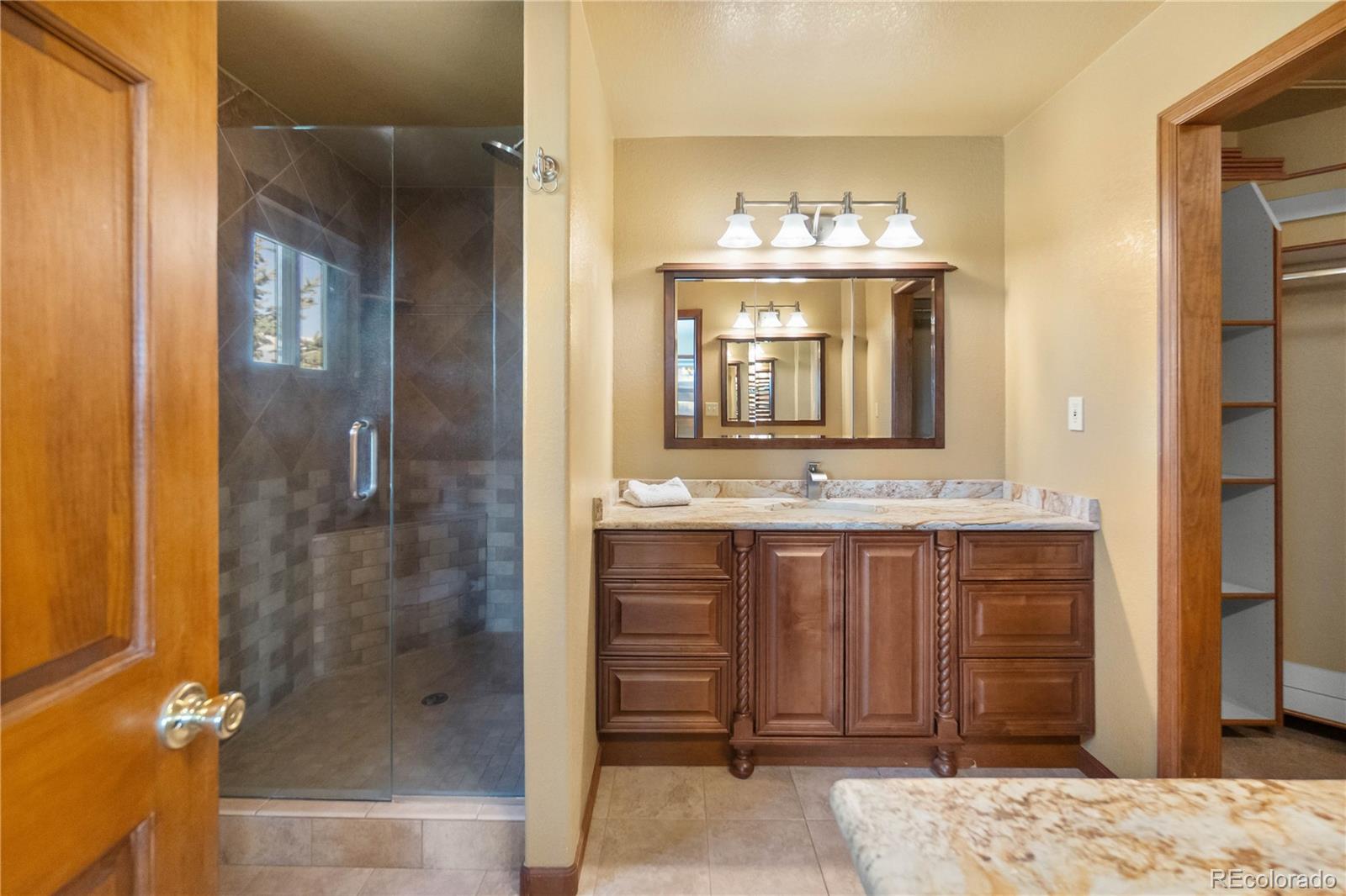 74 Rocky Cliff Road Elizabeth, CO 80107 - Photo 24 of 50 a bathroom with a sink and a mirror
