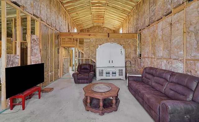 a living room with furniture a flat screen tv and a floor to ceiling window