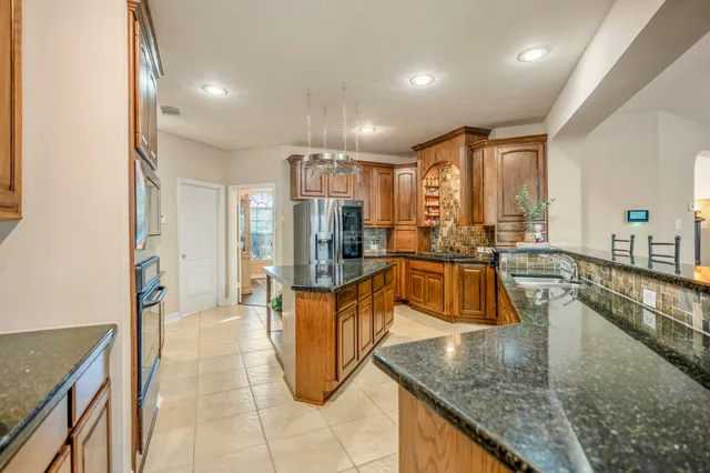 a kitchen with stainless steel appliances granite countertop a sink counter space and cabinets