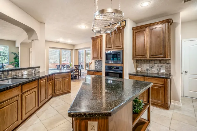 a kitchen with stainless steel appliances granite countertop a stove a sink and a refrigerator