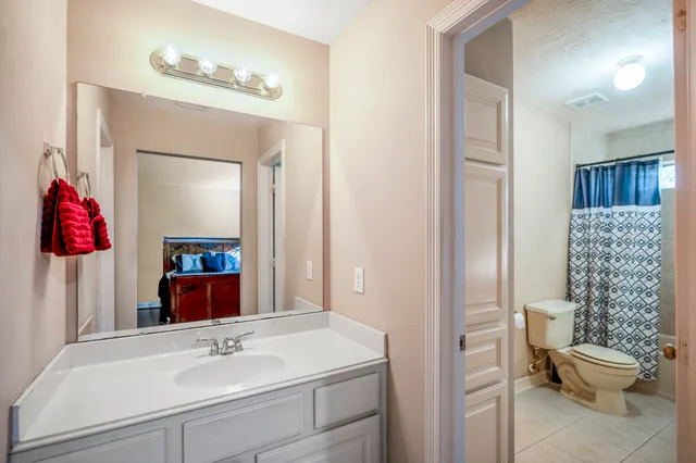 a bedroom with a bed lamp and a large window with wooden floor