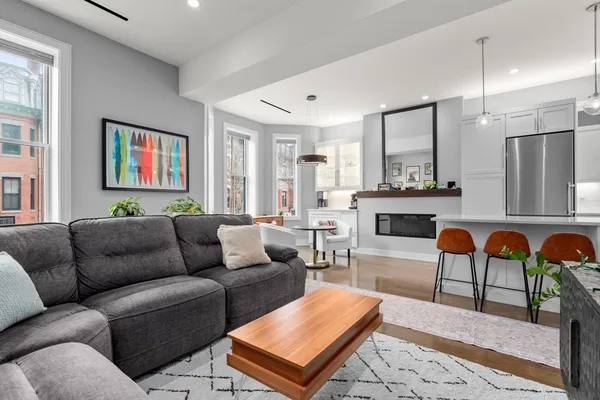 a living room with furniture a fireplace and a large window