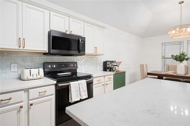 a kitchen with stainless steel appliances a stove microwave and sink