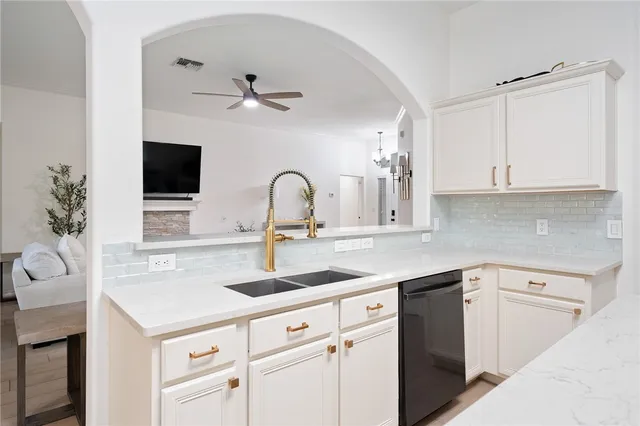 a kitchen with a sink dishwasher and white cabinets